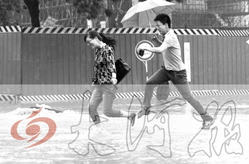 鄭州經(jīng)三路與北環(huán)交叉口處，積水較深，行人們不得不“練輕功”。 記者 白周峰 攝影