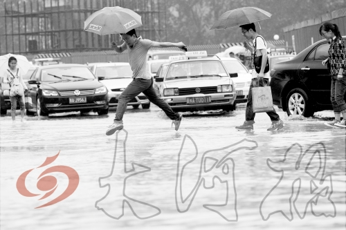 鄭州經(jīng)三路與北環(huán)交叉口處，積水較深，行人們不得不“練輕功”。 記者 白周峰 攝影