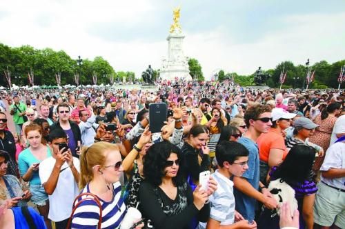 7月23日，在英國倫敦白金漢宮外，民眾們爭相閱讀“王室寶寶”出生的正式公告。