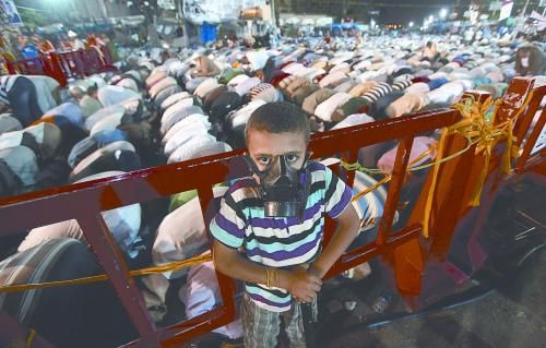 當?shù)貢r間28日晚，在埃及開羅納賽爾城，一名小男孩頭戴防毒面具參加穆兄會的集會示威。