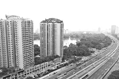 昨日，人濟(jì)山莊小區(qū)，與其他樓相比，B棟樓頂層天臺上違規(guī)建造了一棟兩層小樓，假山大樹俱全。新京報記者