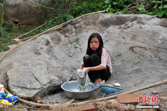 8月9日，云南巧家紅石巖村，10歲的劉鑫蕊在洗自己的衣服