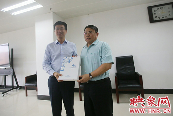 阿里云計(jì)算總裁胡曉明向河南省新聞出版廣電局局長(zhǎng)朱夏炎遞交《中原云平臺(tái)交付手冊(cè)》。