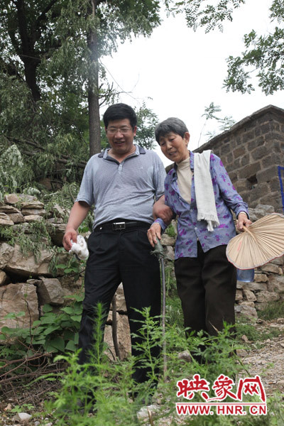 海付恒攙著患有腿部風濕性關節(jié)炎的劉梅英下山 海付恒攙著患有腿部風濕性關節(jié)炎的劉梅英下山