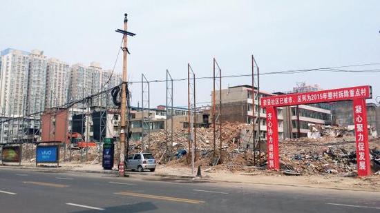 015年5月31日，在社區(qū)干部的帶頭拆遷下，親賢社區(qū)的“城中村改造”拉開(kāi)帷幕。由于前期“清產(chǎn)核資”及補(bǔ)償標(biāo)準(zhǔn)等因素，拆遷改造工作推進(jìn)并不順利。圖為位于體育西路東側(cè)集體所有的商鋪率先被拆遷完畢，用于遮擋的圍擋正在施工中。（拍攝：2015年9月16日）