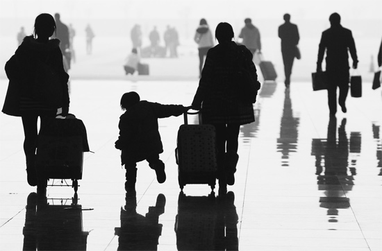 昨日，鄭州東站，一名孩子拉著媽媽和包裹快樂地奔走在春運(yùn)的途中