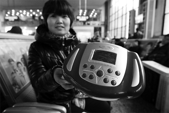 火車站候車室，李女士向記者展示她準(zhǔn)備孝敬父母的按摩儀