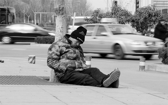 2月2日，鄭州市中州大道農(nóng)業(yè)路立交橋下，50歲的王文德打算在臨近春節(jié)前再接些零活兒，由于疲憊，他睡著