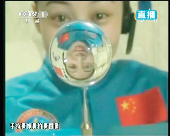 王亞平的倒影出現(xiàn)在水球中。新華社發(fā)（視頻截圖）