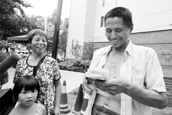 昨日，鄭州市明達(dá)路與豐慶路交叉口西300米路南，來自中牟的瓜農(nóng)拿到西瓜款，笑開顏東方今報(bào)記者袁曉強(qiáng)