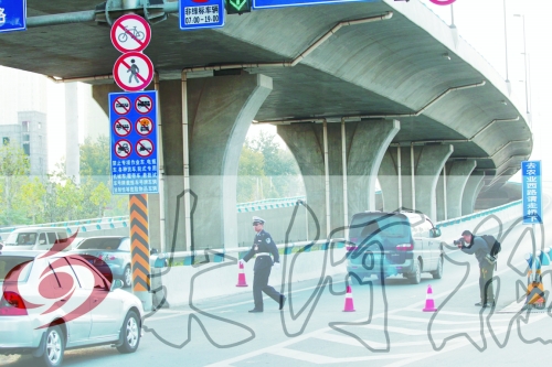 交警在東風(fēng)路從北向南上橋口處擺上反光錐，間歇放行