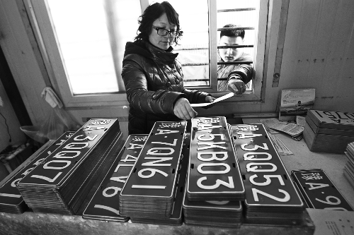 鄭州市車管所工作人員正忙著把新制作的車牌發(fā)給等待的車主 鄭州市車管所工作人員正忙著把新制作的車牌發(fā)給等待的車主