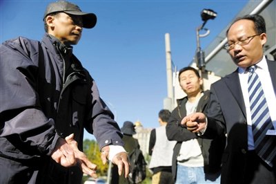 常林鋒在法院外展示雙手，他稱被燙傷的手因刑訊逼供且未得到及時救治