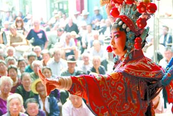 圖為8月15日戲曲演員在“流動(dòng)舞臺(tái)車”上表演傳統(tǒng)地方戲《穆桂英下山》。