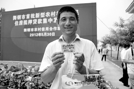 領(lǐng)到貸款，農(nóng)民開心地笑了。