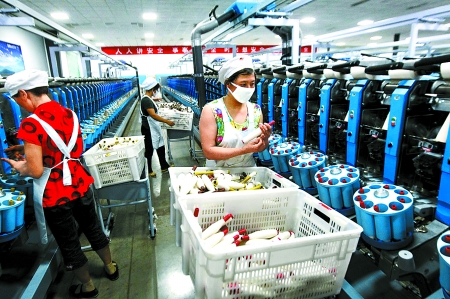 6月6日，舞鋼市鑫海紡織有限公司員工正在新建成的紡紗車間生產(chǎn)。