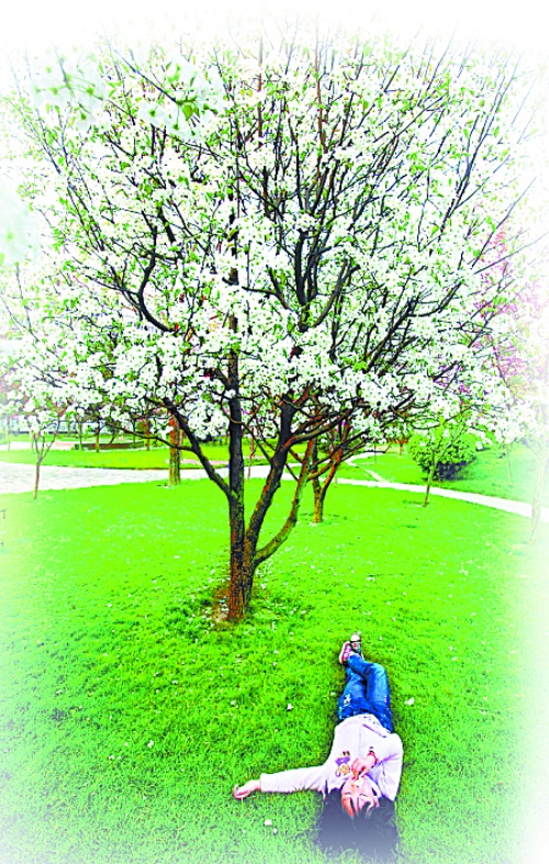 　孩子愜意地躺在社區(qū)內(nèi)的草坪上。