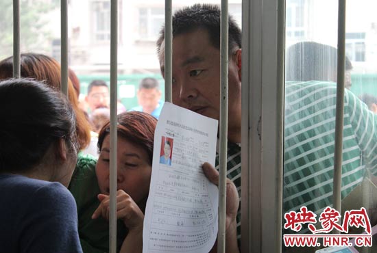 不少家長擠在報名窗口前咨詢報名事宜。