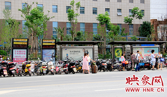 在黃河路經(jīng)三路公交站牌候車(chē)的乘客被“擠”到了路上 在黃河路經(jīng)三路公交站牌候車(chē)的乘客被“擠”到了路上