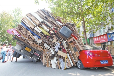 紅色小轎車被砸，卡在路邊動彈不得。