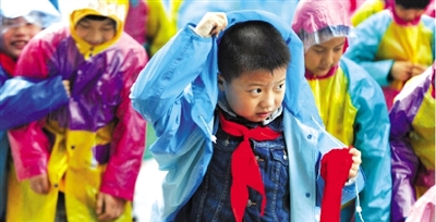 昨日下午,農(nóng)科路上一小學放學時,孩子們大部分都穿著雨披。