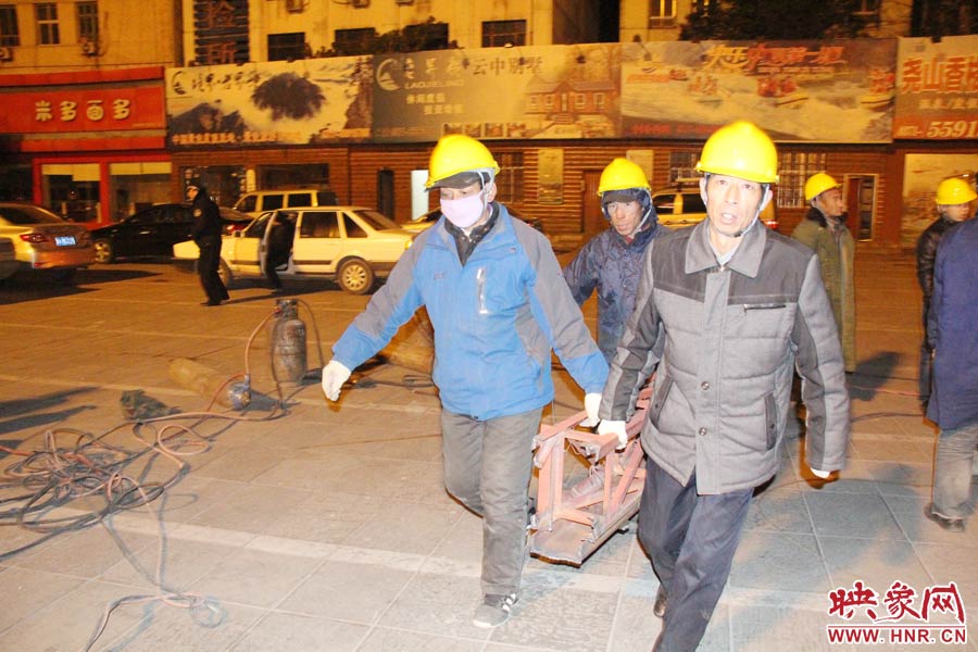 23點(diǎn)56分，第一塊兒廣告牌已經(jīng)分割完畢，地面上的20多名工人將拆除下來(lái)的鋼件撞車運(yùn)走。