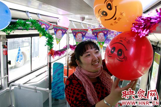 鄭州快速公交B3區(qū)間線車長李鵬云在車廂里懸掛氣球，布置圣誕車廂，營造歡樂圣誕氛圍