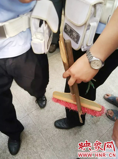 老太從環(huán)衛(wèi)工手中奪過(guò)掃帚，用腳踩斷，用力向環(huán)衛(wèi)工人的手上和腿上敲去。