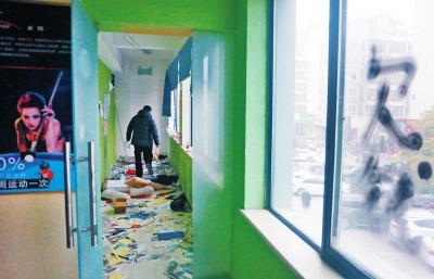 　健身會所地上一片狼藉，玻璃上噴著黑色“欠錢”二字。