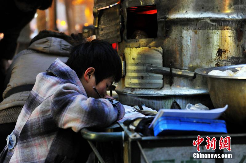 男孩西安路燈下寫作業(yè) 媽媽邊賣紅薯邊輔導 男孩西安路燈下寫作業(yè) 媽媽邊賣紅薯邊輔導