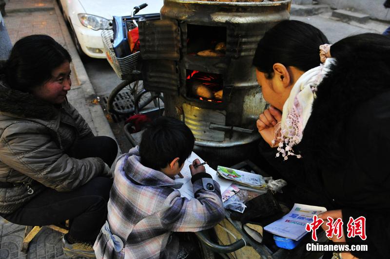 男孩西安路燈下寫作業(yè) 媽媽邊賣紅薯邊輔導 男孩西安路燈下寫作業(yè) 媽媽邊賣紅薯邊輔導