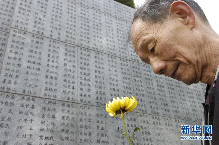 2006年4月5日，74歲的南京大屠殺幸存者佘子清手捧鮮花，祭奠被日軍殺害的母親。