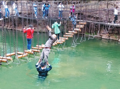中年男游客正踩著景區(qū)安全員郭小明的肩膀過(guò)河。網(wǎng)友“@我的小名叫張孩”供圖