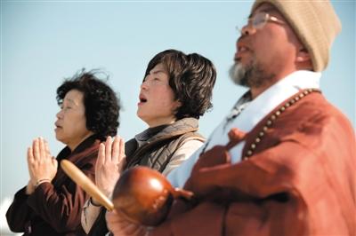 23日，一名僧侶引領(lǐng)人們?yōu)樗勒咂矶\。