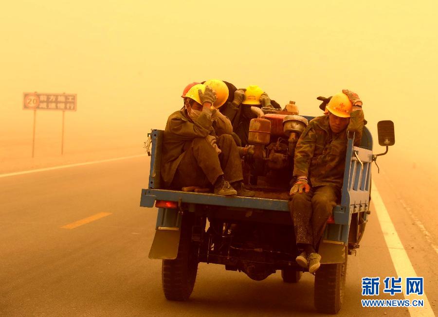 4月23日，一輛拉載公路施工人員的三輪車在沙塵暴中行駛在酒泉市瓜州縣城郊的公路上。