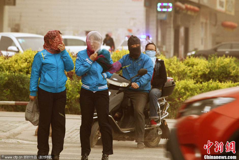 2014年04月23日，新疆維吾爾自治區(qū)吐魯番地區(qū)，市民戴著口罩行走在大風(fēng)沙塵中的吐魯番市街頭。