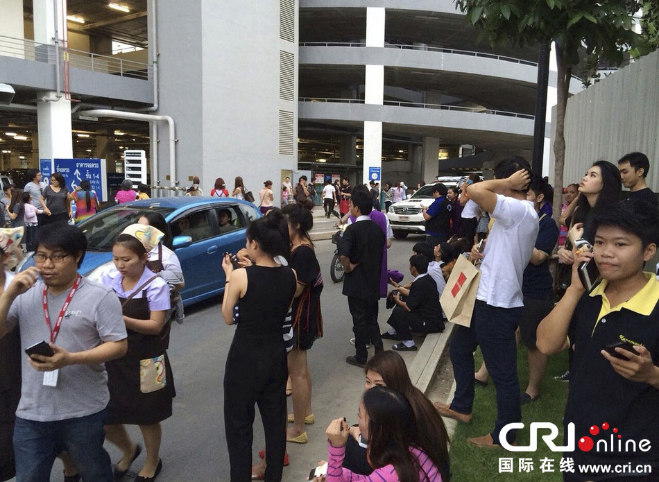 當?shù)貢r間2014年5月5日，泰國清萊，工人們站在一棟大樓外避難。