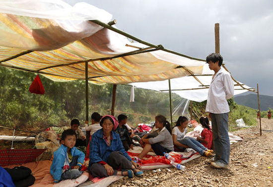 暴雨馬上來臨，村民們在簡易帳篷下躲雨。澎湃新聞 程藝輝 圖