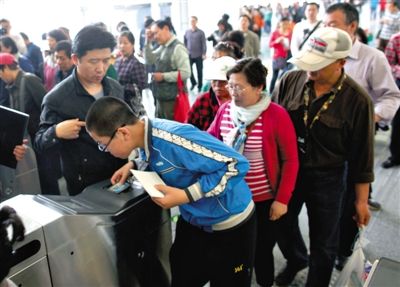 去年5月5日，14號(hào)線園博園站，乘客刷卡出地鐵。北京公交地鐵將實(shí)行計(jì)程票制，多乘坐多付費(fèi)。