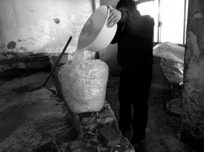 作坊內(nèi)工人用攪拌有漂白粉的藥水給豆芽增白。