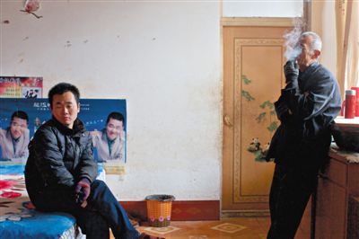 父親抽煙，兒子不語。逃跑的越南新娘，給袁迎賓父子帶來的是失落。新京報記者