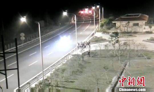 看到車輛經(jīng)過，孩子們便急忙跑到一旁的花圃上?！【焦﹫D　攝