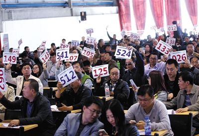 競拍者正在練習(xí)舉牌動作，以便拍賣時讓工作人員看清號牌。