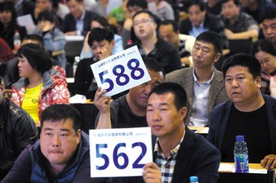 昨日，拍賣現(xiàn)場競拍者舉牌競拍。新京報記者