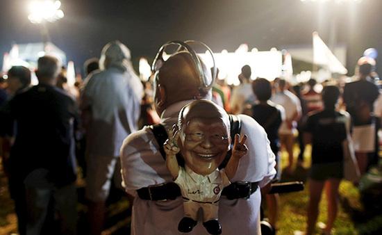 9月4日，新加坡，執(zhí)政黨的一場(chǎng)集會(huì)上，一名支持者背著一個(gè)李光耀的人偶。