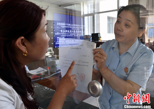 資料圖：2015年5月4日，河北石家莊市橋西區(qū)人民法院立案庭庭長齊燕正在為立案人辦理相關(guān)手續(xù)，完成整個過程只用了5分鐘。當(dāng)日是立案登記制改革首個工作日，該院共立案36件，立案率達(dá)到90%。中新社發(fā) 翟羽佳 攝