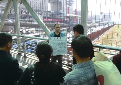 韓先生在北京西站天橋上籌錢。京華時(shí)報(bào)記者陶冉攝