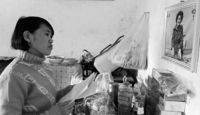 錢仁鳳站在母親遺像前。未能見母親最后一面是她的一大遺憾。