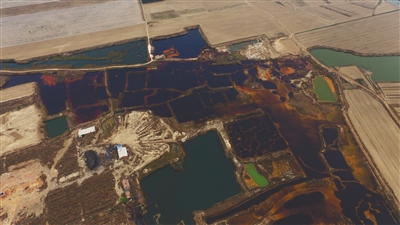 4月19日，廊坊市大城縣南趙扶鎮(zhèn)，津保路以北約八九百米處，一個(gè)巨大的污水坑中，水體呈現(xiàn)紅褐色。 新京報(bào)記者 尹亞飛 攝