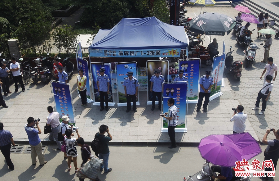 執(zhí)法人員用宣傳牌圍擋占道經(jīng)營(yíng)攤位。